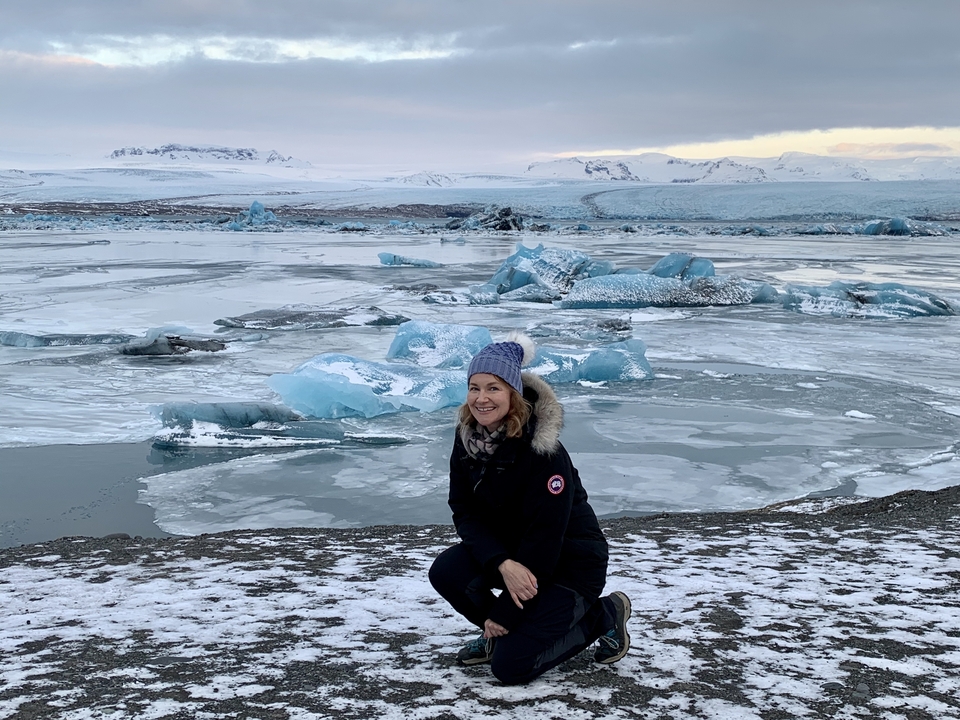 Femme agenouillée près d'un lagon glacé.