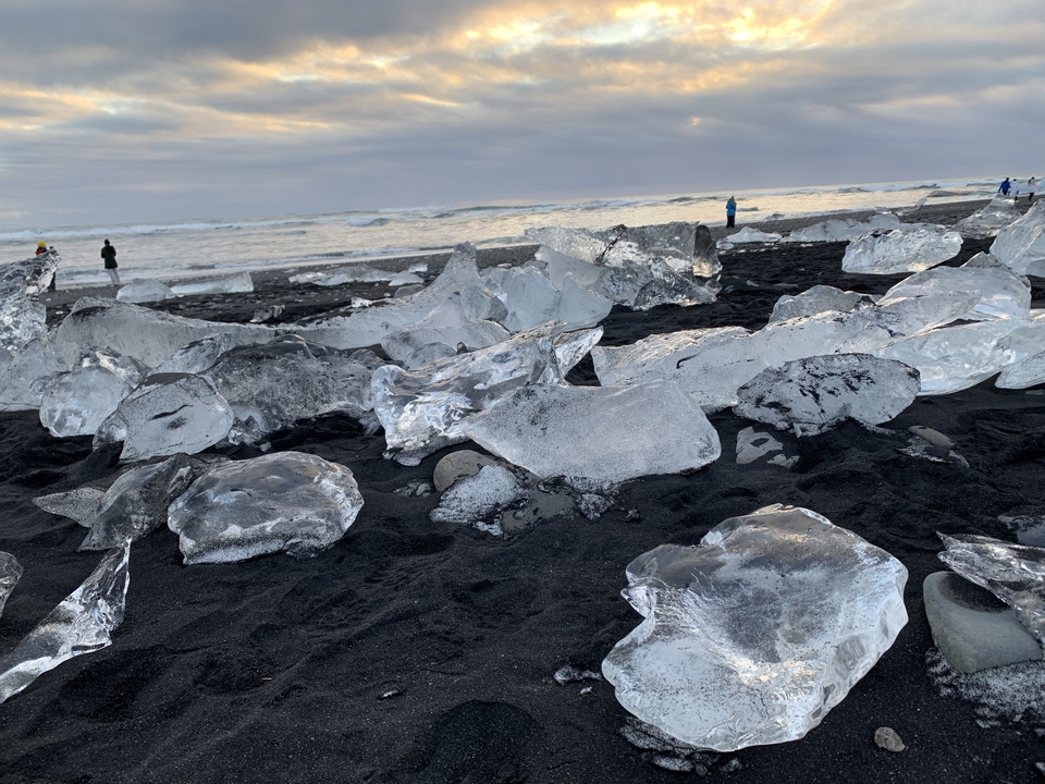 Des morceaux de glace sur une plage de sable noir.