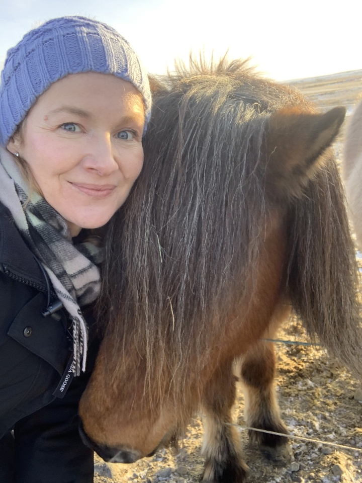 Gros plan d'une femme et de la crinière d'un cheval.