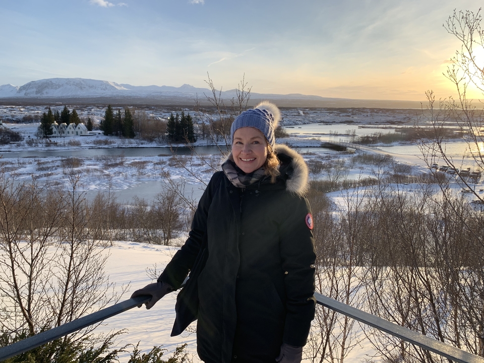 Femme debout avec un paysage enneigé et une vue sur la rivière.