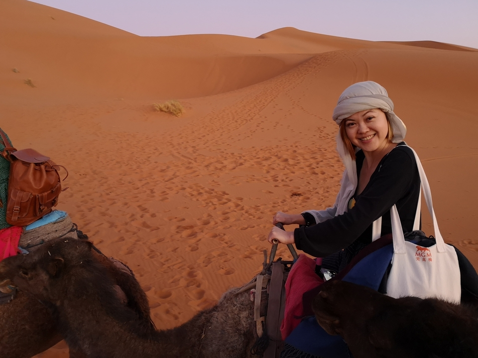 Person riding a camel in the desert.