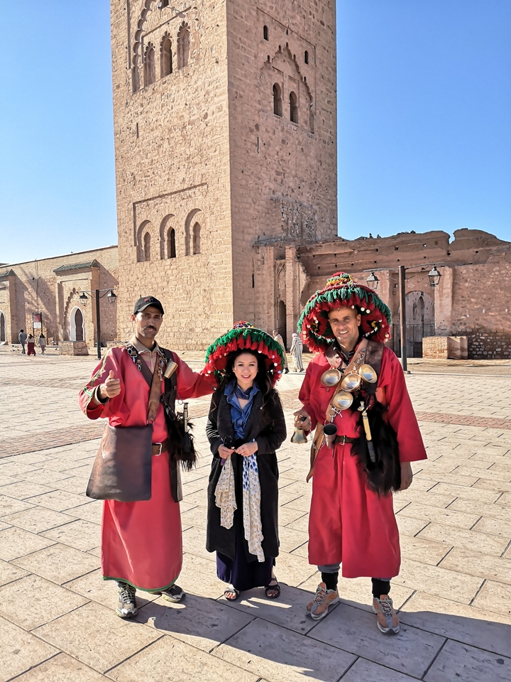 Person posing with traditionally dressed locals.