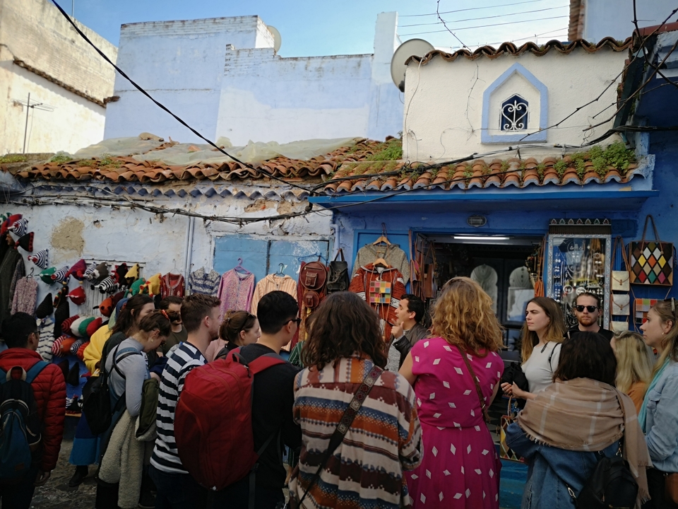 Crowd of people in a colorful market street.