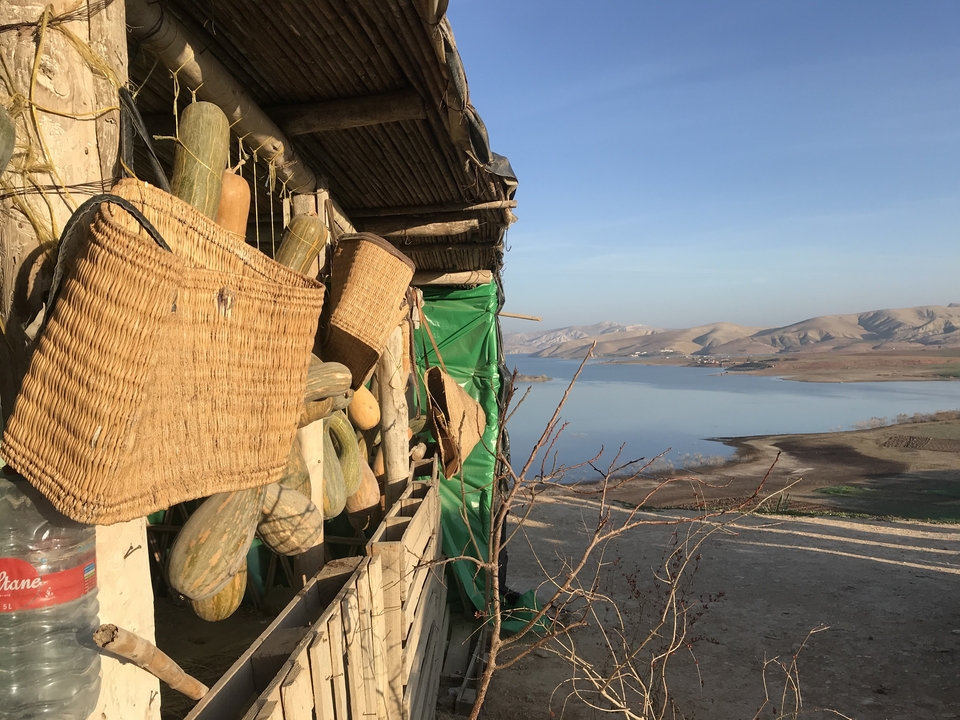 Paniers et gourdes suspendus à l'extérieur d'un magasin donnant sur un lac.