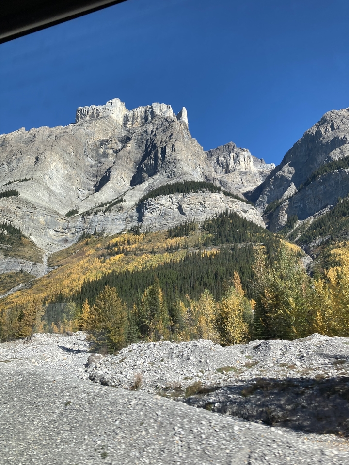 Paysage de montagne avec feuillage d'automne coloré sous un ciel bleu clair.