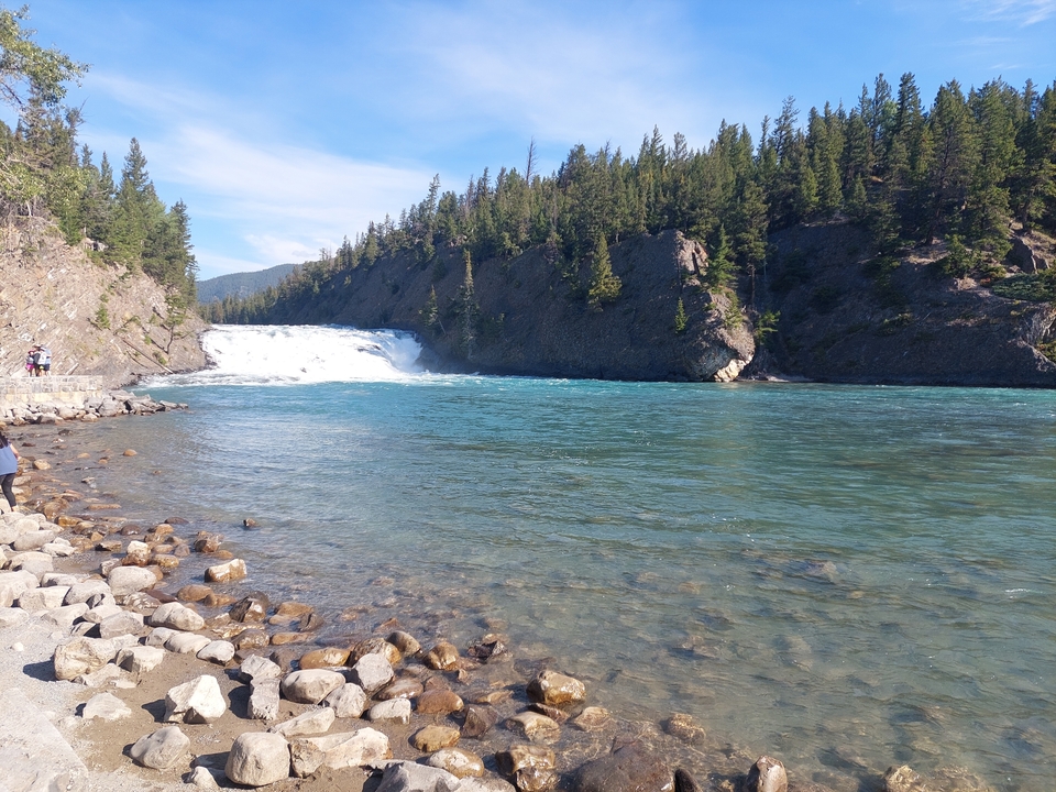 Cascade avec un rivage rocheux et une forêt.