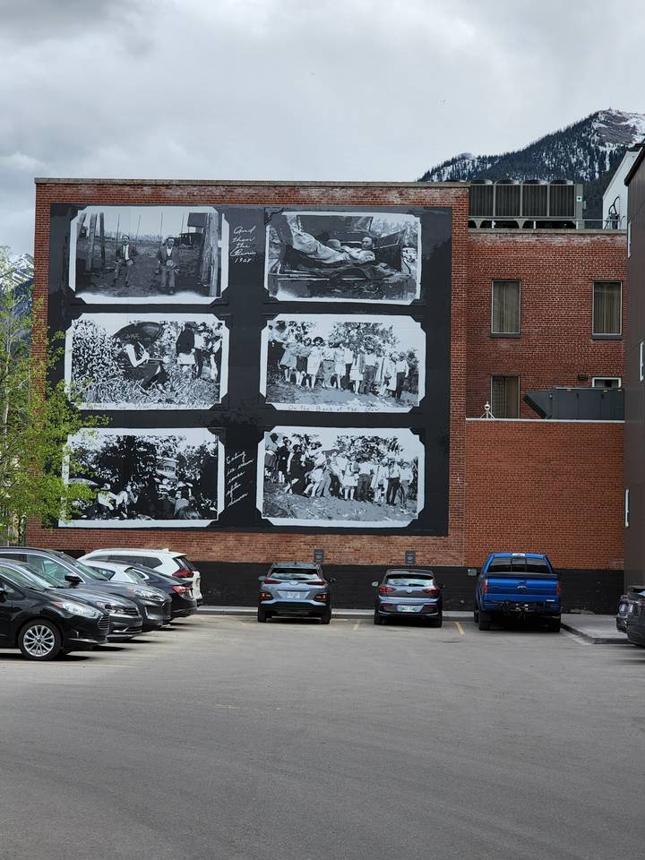 Anciennes photographies exposées sur un mur dans une zone de stationnement.
