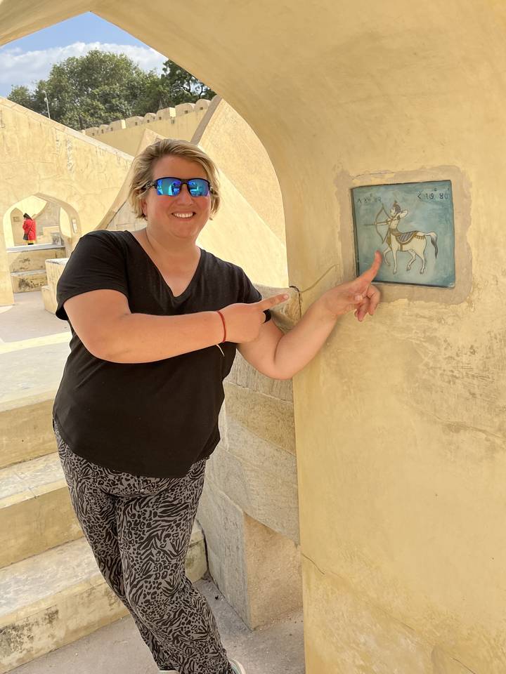 Individu pointant du doigt un détail architectural sur un mur.