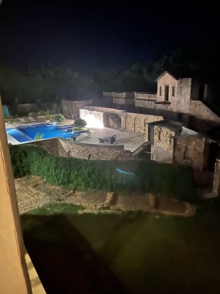 Scène de nuit d'un extérieur de bâtiment avec des éclairages décoratifs.