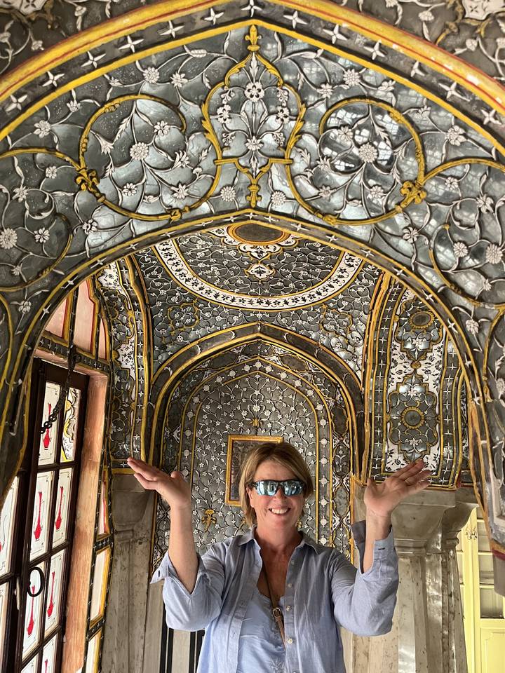 Personne posant sous un plafond décoratif au design élaboré.