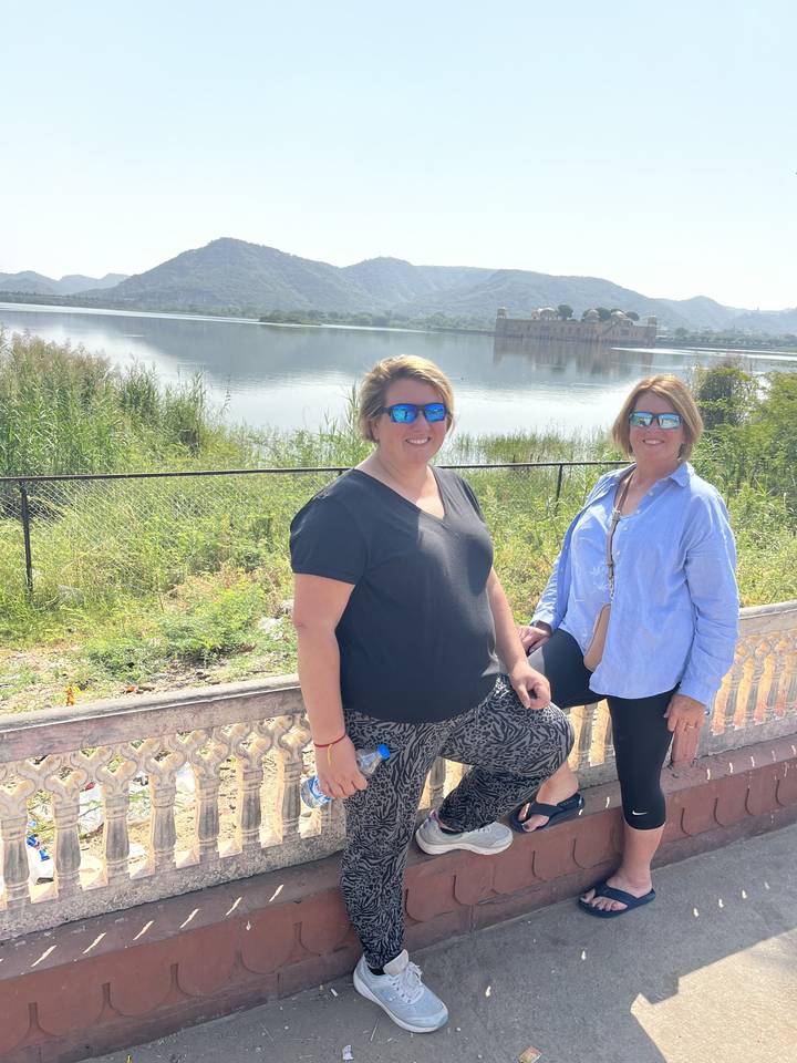 Deux individus se relaxant près d'une grande étendue d'eau avec des collines.