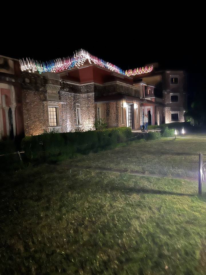 Extérieur de bâtiment avec éclairage décoratif dans un cadre de jardin la nuit.