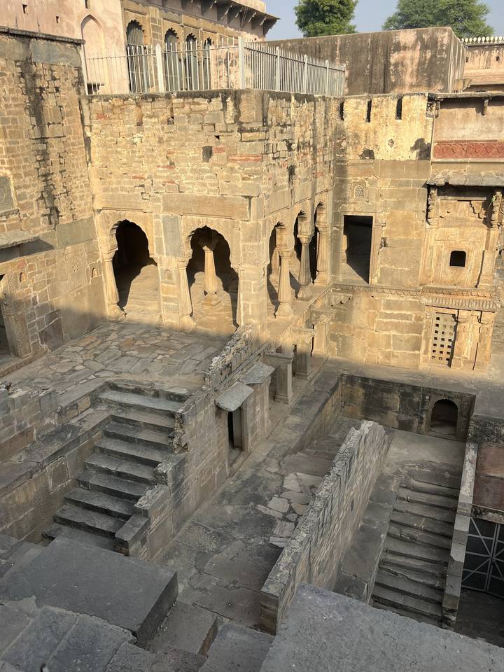 Ancienne structure de pierre avec arches et escaliers.