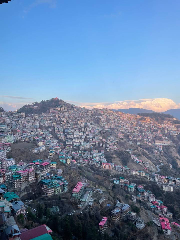 Luchtfoto van een dichtbebouwde stad op een heuvel met gebouwen.