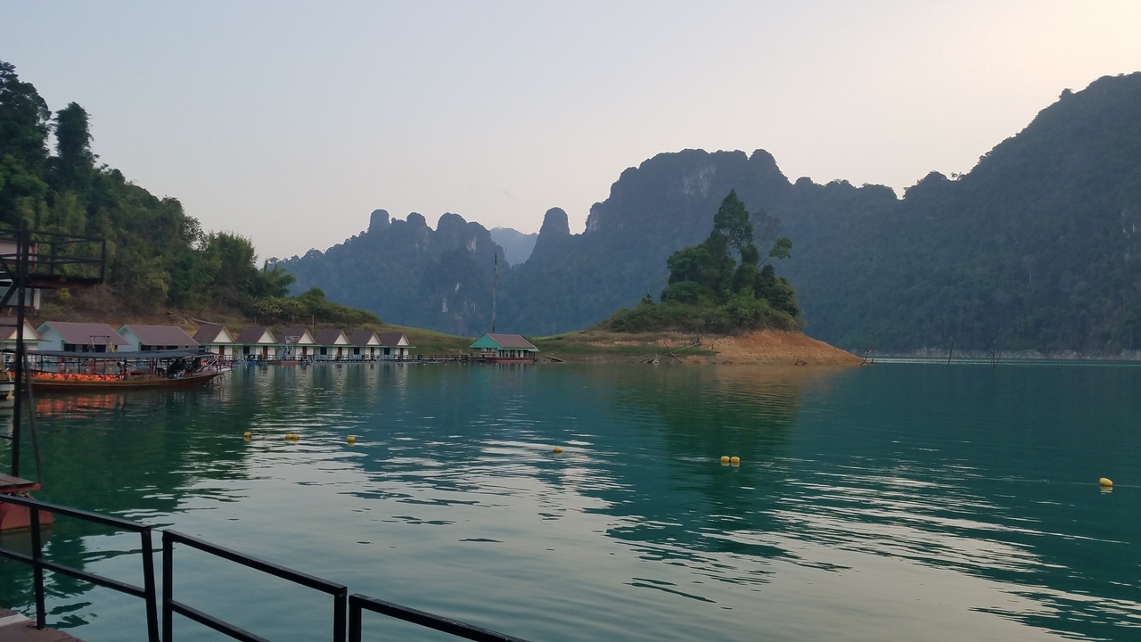 Floating cottages on a lake surrounded by mountains.