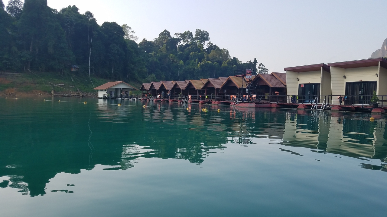 Row of floating cabins on a serene lake.