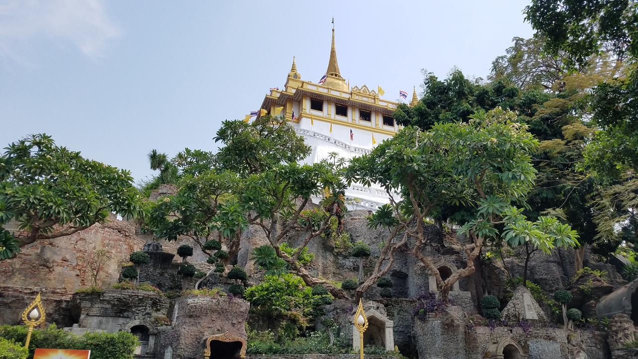 Temple atop a hill surrounded by lush greenery.