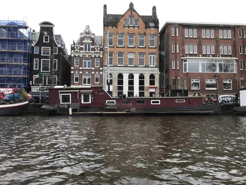 Maisons traditionnelles au bord du canal avec un bateau.