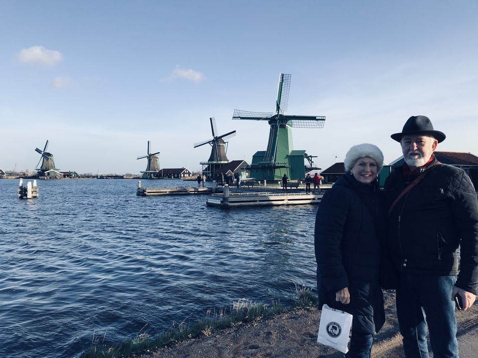 Couple posant avec des moulins à vent et un cours d'eau.
