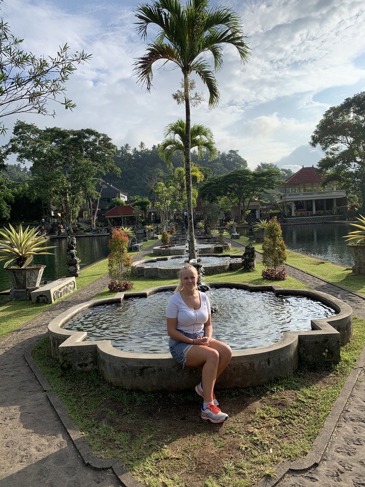 Personne assise dans un point d'eau dans un cadre de jardin.