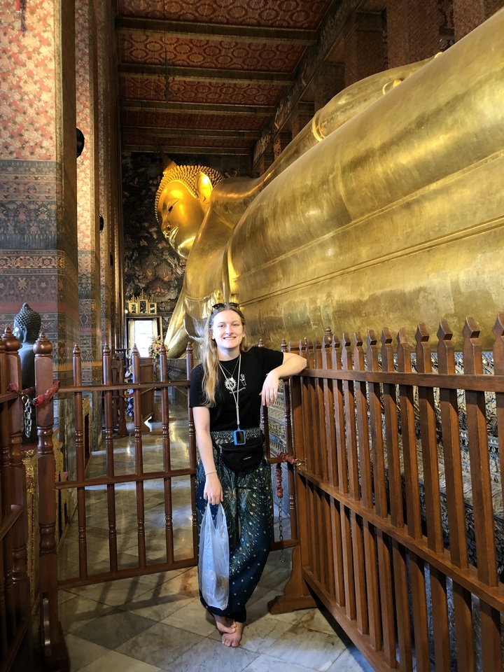 Personne posant devant la statue du Bouddha couché.