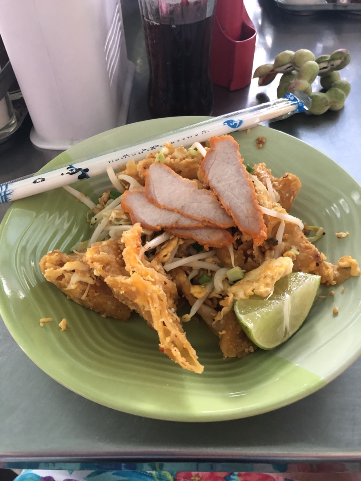 Assiette de nourriture avec porc tranché, pousses de soja et citron vert.