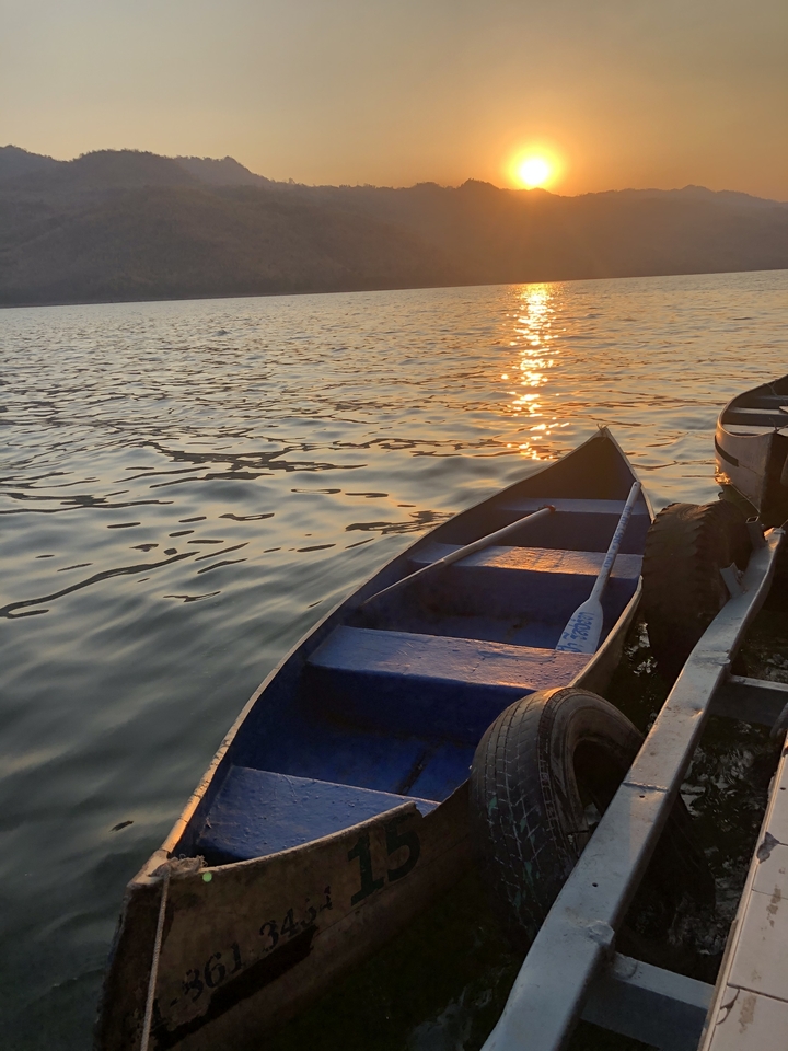 Barque sur un lac calme au coucher du soleil.