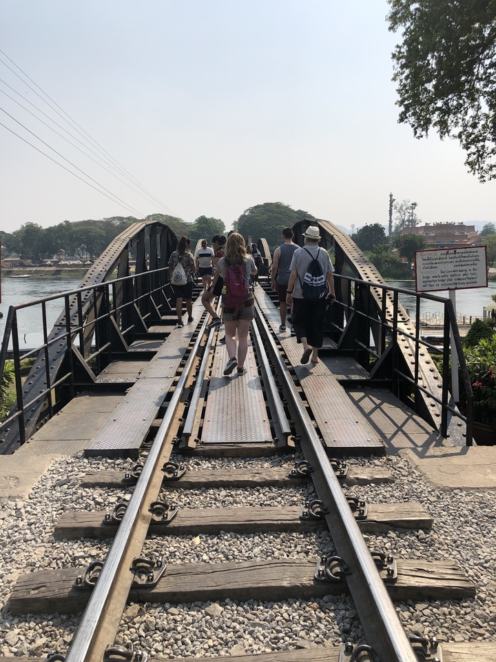 Des touristes marchant sur un pont ferroviaire historique.