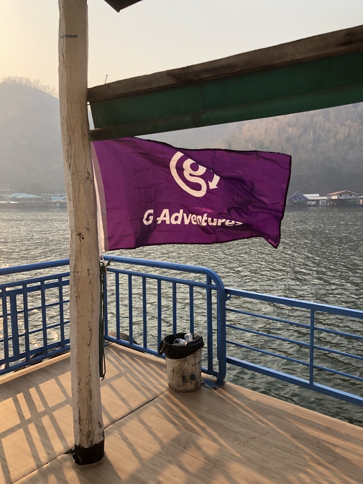 Drapeau avec le logo 'G Adventures' sur un quai de bateau.