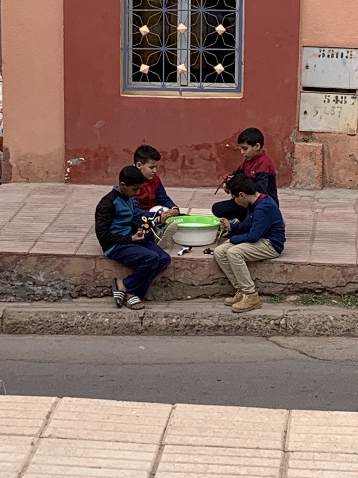 Groupe de garçons assis sur une marche avec des jouets dans un cadre décontracté.