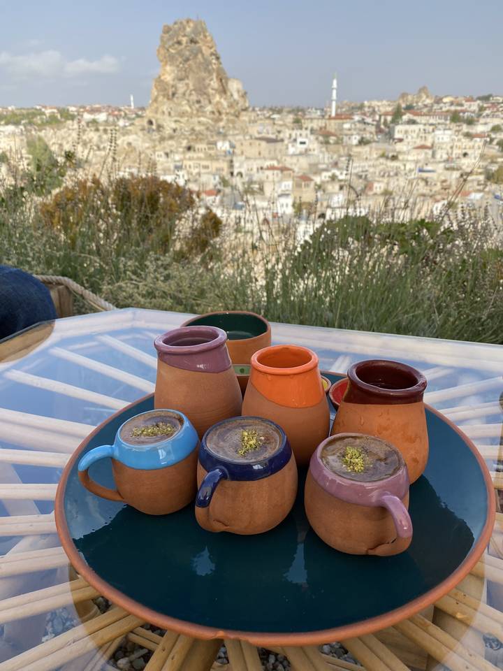 Une table avec des tasses en poterie colorées sur un arrière-plan pittoresque.