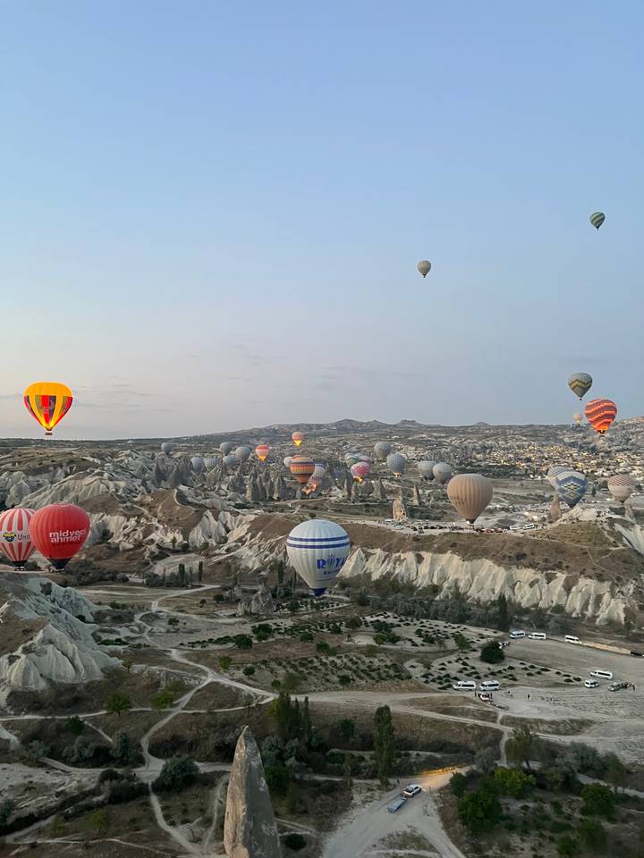 De nombreuses montgolfières flottant au-dessus d'un paysage rocheux.