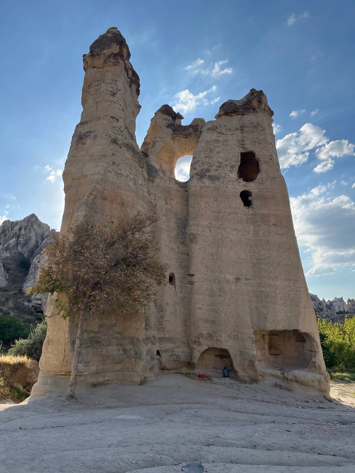 Hautes formations rocheuses avec des trous sous un ciel bleu.