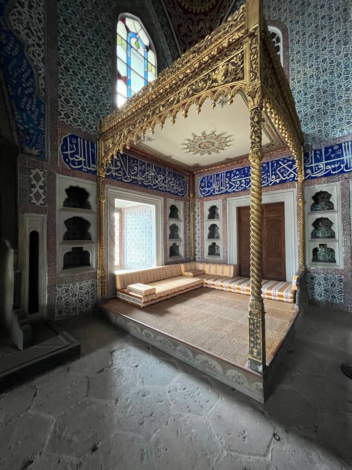 Intérieur complexe d'un bâtiment historique avec des inscriptions arabes.