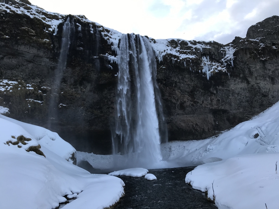Waterfall surrounded by snow and ice.
