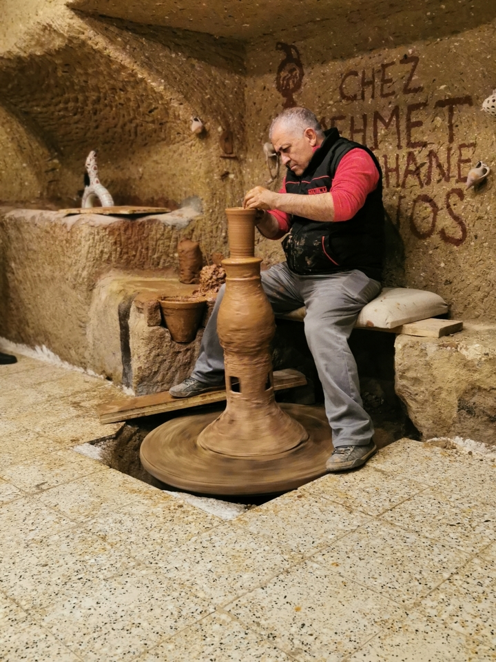 Un potier à l'œuvre façonnant l'argile sur un tour.