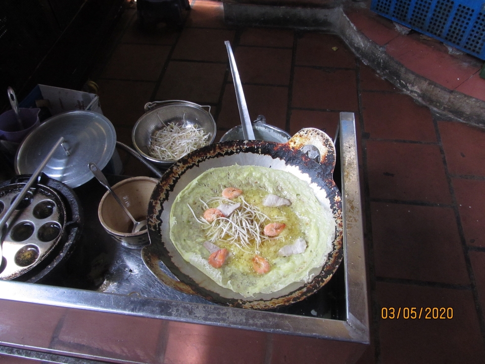 Crêpe vietnamienne qui cuit dans une poêle.