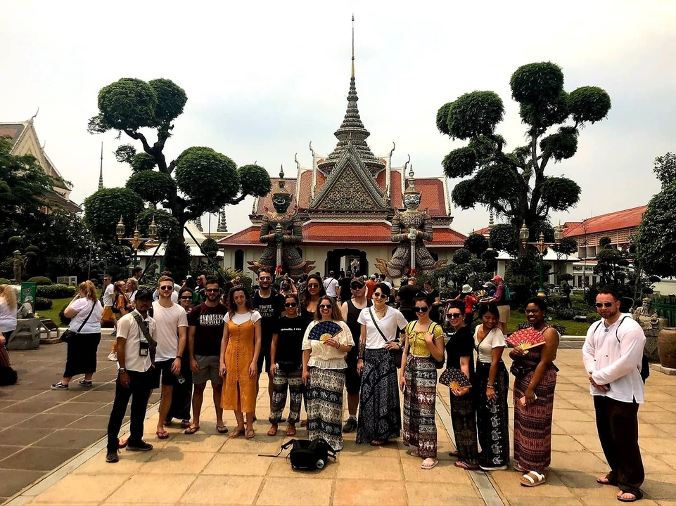 Group of tourists posing in front of a temple with unique landscape features.