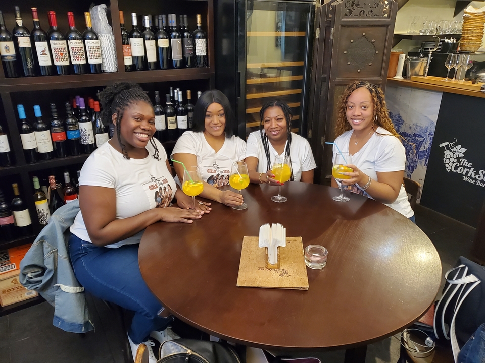 Groupe de quatre femmes savourant des boissons à une table dans un cadre chaleureux.