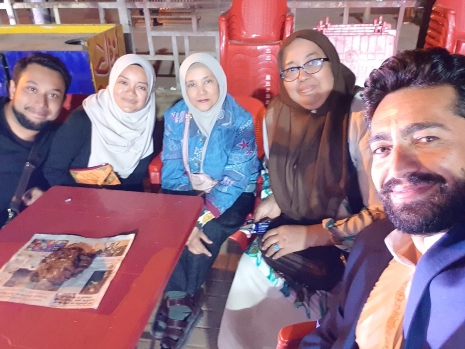 Group of people seated and eating together at a table.