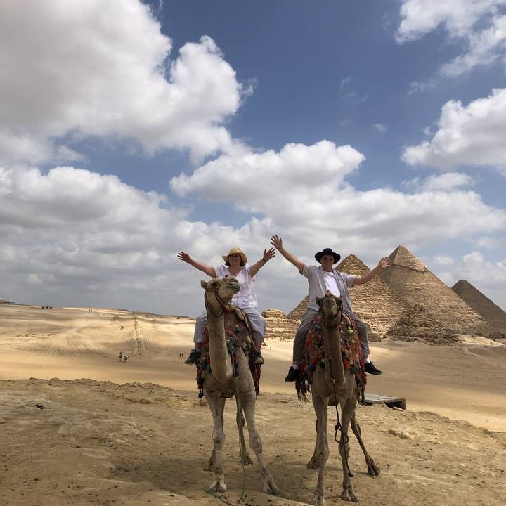 Deux personnes montant des chameaux près des pyramides.