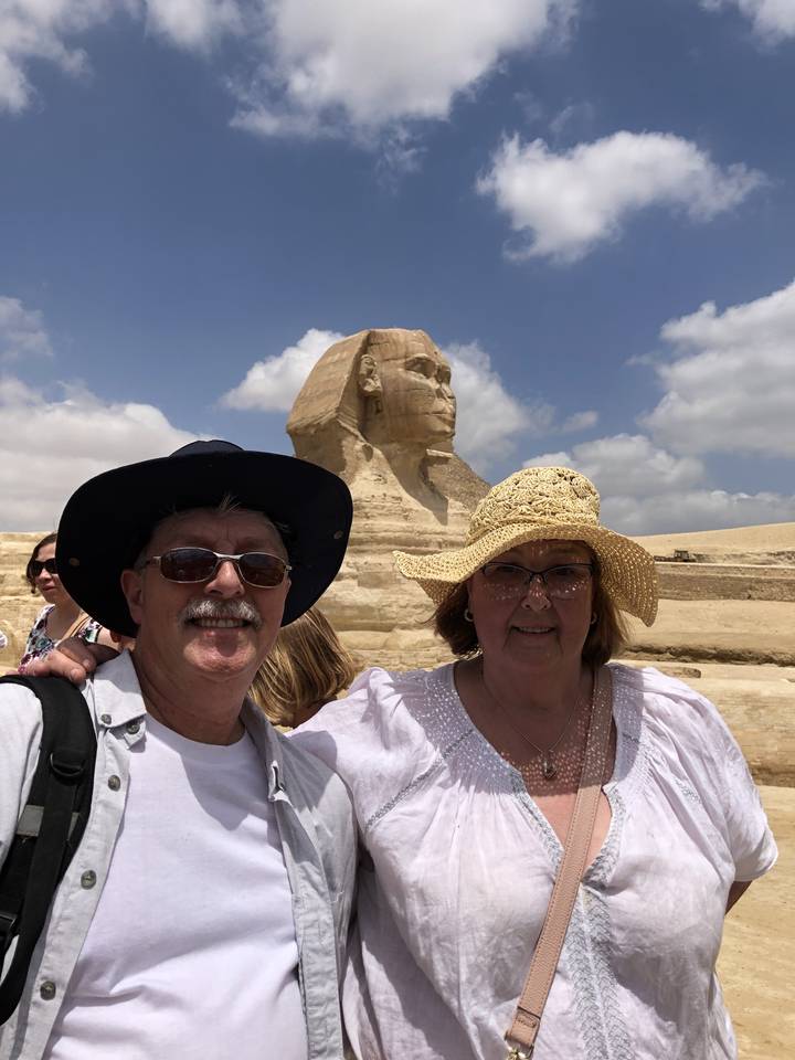 Couple posant avec le Sphinx en arrière-plan.