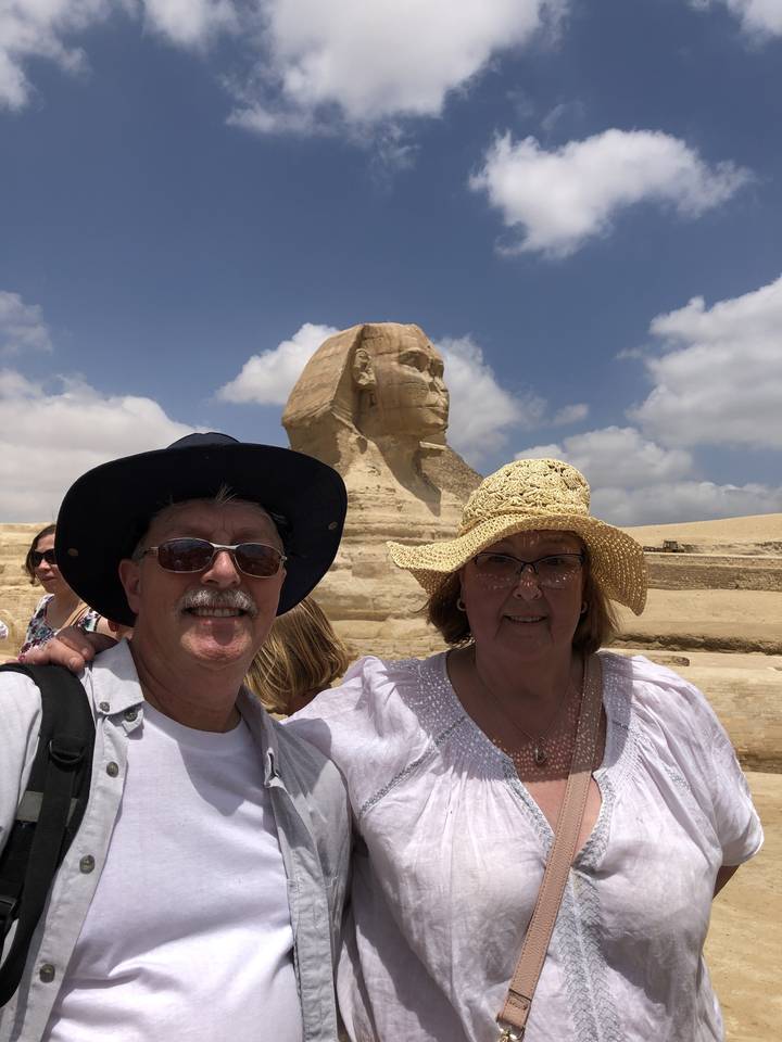 Couple posant avec le Sphinx en arrière-plan.