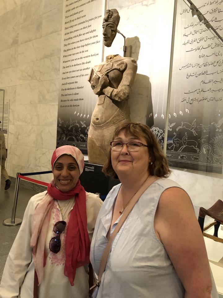 Deux personnes posant avec une statue antique à l'intérieur.