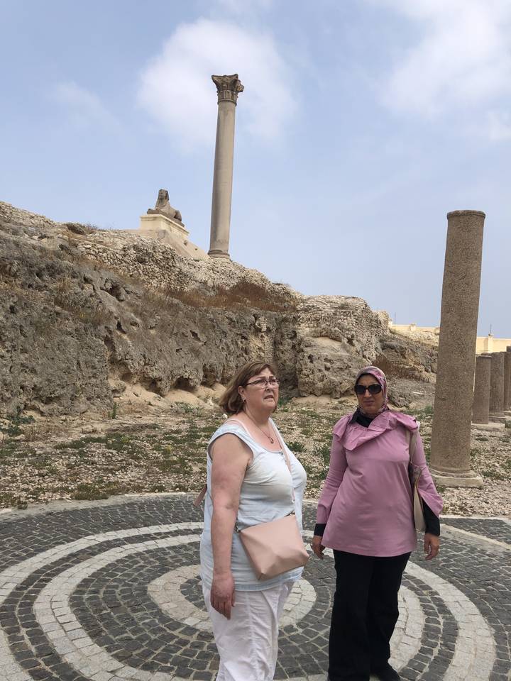 Deux personnes posant dans un décor de ruines avec une colonne et des ruines.