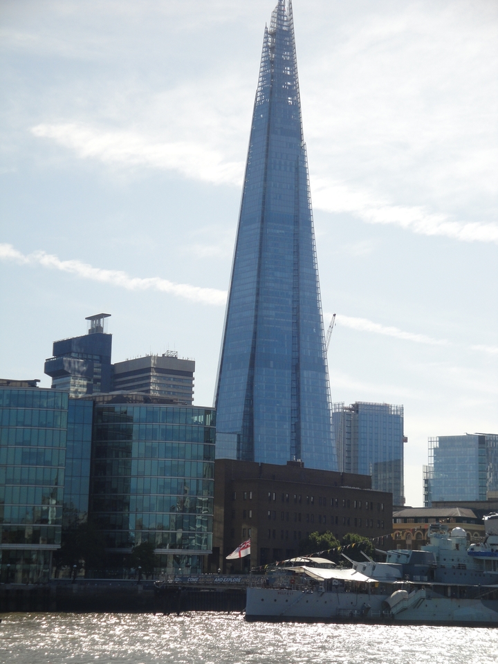 A cityscape featuring a modern skyscraper under a clear sky.