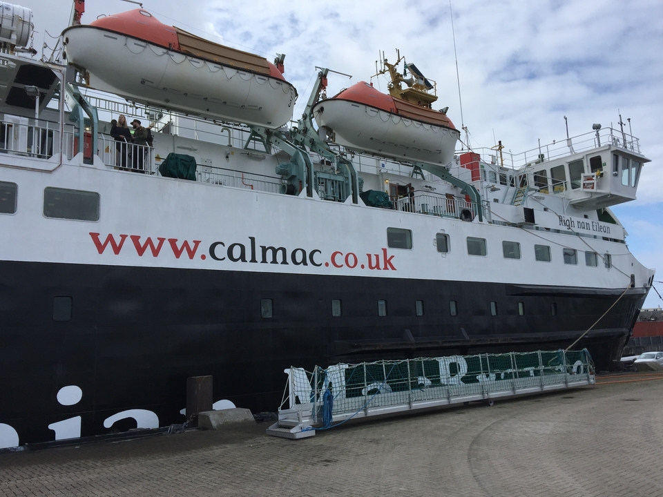Un grand ferry amarré avec des passagers visibles.