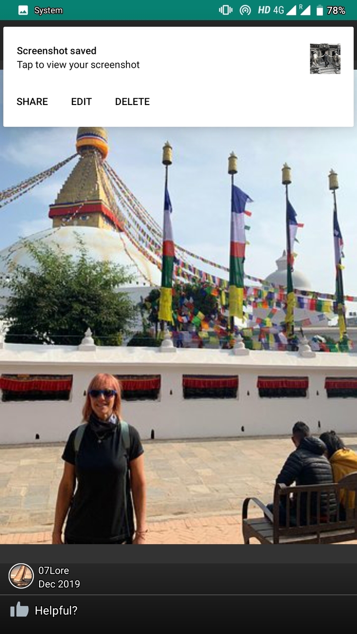 Personne devant un bâtiment avec des drapeaux colorés en arrière-plan.