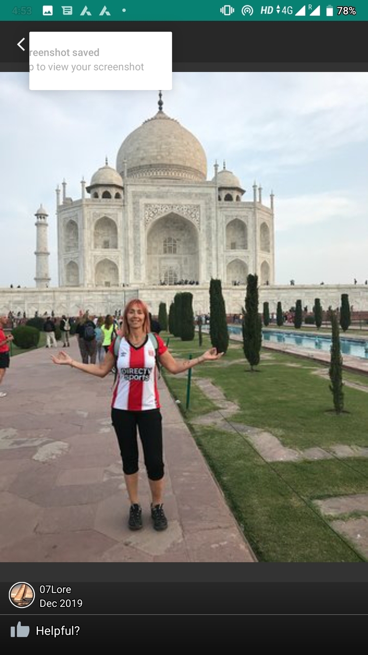 Femme posant devant le Taj Mahal avec les bras étendus.