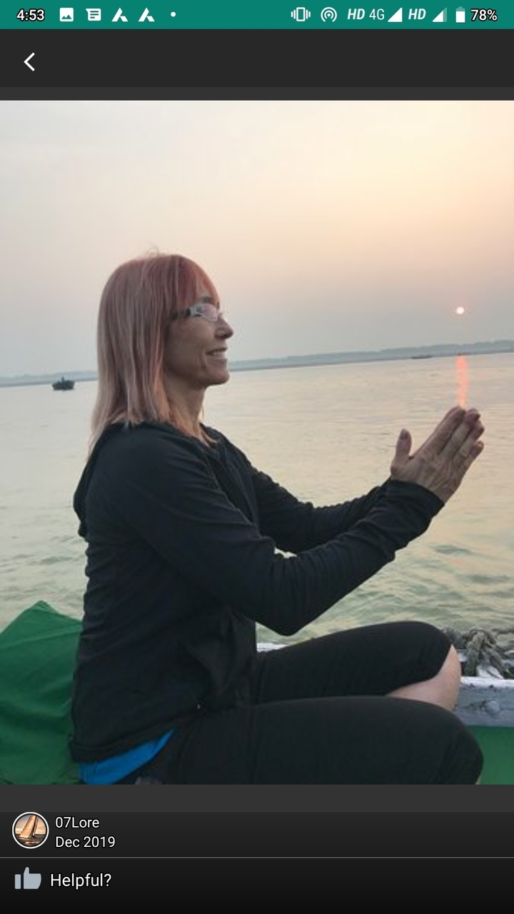 Femme pratiquant le yoga au bord d'une rivière ou d'un lac au coucher du soleil.